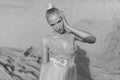 Front portrait of a beautiful young woman posing in the desert, looking at camera. Black and white image. Royalty Free Stock Photo