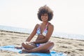 Young beautiful afro american woman sitting on beach Royalty Free Stock Photo