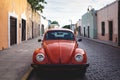 Front of red Oldtimer Volkswagen Beetle in the colonial streets of Merida at `Casa Culcal Kin`, Yucatan, Mexico