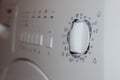 Front rotate dial knob of white clothes washing machine - selective focus Royalty Free Stock Photo