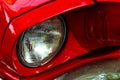 Front round headlight of a red retro car. Detail of an old vintage car. Modern tuning. Royalty Free Stock Photo