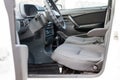 Front row gray fabric driver`s and passenger seats with a black control panel and center console with plastic steering wheel and Royalty Free Stock Photo