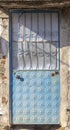 Front shot of traditional ornamented pale blue metal door at sunset Royalty Free Stock Photo