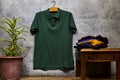 Front side of male green cotton t-shirt hanging on gray grunge marble wall Royalty Free Stock Photo