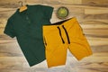 Front side of male green cotton t-shirt with mustard color short on wood floor with cactus pot Royalty Free Stock Photo