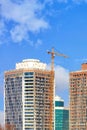 Fragment of construction of modern residential skyscrapers by tower crane on a background of blue sky Royalty Free Stock Photo