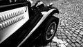 Front side part of vintage classic black hot rod car on a cobble road Royalty Free Stock Photo