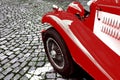 Front side part of vintage classic red hot rod car on a cobble road Royalty Free Stock Photo