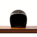Front side view of black color vintage style motorcycle helmet on natural wooden desk.Concept classic object white Royalty Free Stock Photo