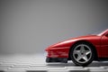 Front side view of a Red toy Ferrari 348TB sports car close up product shot on a chequered ground and gray background Royalty Free Stock Photo