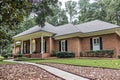 A front side view of an updated spacious red brick ranch traditional house home with off white columns and brick front Royalty Free Stock Photo