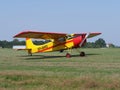 Front and side of Yakovlev Yak-12M SP-AWG airplane lands on green grassy airfield in european Bielsko-Biala city, Poland