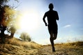 Front silhouette young sport man running cross country workout at summer sunset Royalty Free Stock Photo