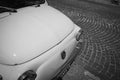 Front of small Italian iconic car in birds eye perspective on European cobbled street