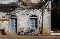 Front of small picturesque store or resturant with table and chairs on sidewalk closed for holiday on main street of small Greek t