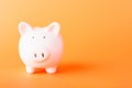 Front small white fat piggy bank, studio shot isolated on orange