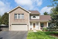 Front of a suburban house with brick and vinyl siding.