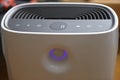 Modern air purifier with digital display, touch control icons and glowing purple air quality sensor ring Royalty Free Stock Photo