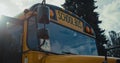 Front view academic bus window with warning sign yellow red headlights close up. Royalty Free Stock Photo