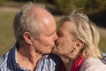 Senior couple kissing each other in the park Royalty Free Stock Photo