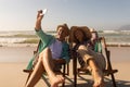 Senior couple taking selfie with mobile phone while relaxing on sun lounger at beach Royalty Free Stock Photo