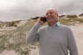 Happy senior man talking on mobile phone at beach Royalty Free Stock Photo