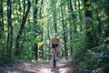 Front view of active senior woman biker cycling outdoors in forest. Royalty Free Stock Photo