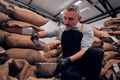 Front view of adult man pouring raw coffee beans in a bawl