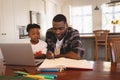 African American father helping his son with homework at table Royalty Free Stock Photo