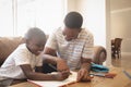 Front view of African American father helping his son with homework at table Royalty Free Stock Photo