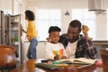 African American father helping his son with homework at table Royalty Free Stock Photo