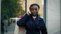 Front view african american girl shopper shopaholic consumer standing on city street near building after shopping with