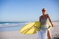Woman with surfboard sitting on bicycle at beach in the sunshine Royalty Free Stock Photo