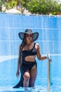 Front view of an African-American woman wearing swimwear exiting the pool by the ladder