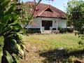 front view of an ancient Javanese traditional house that is still well maintained with a neat garden