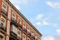 Front view on antique facade made of red brick with retro metallic balconies in Madrid, Spain. Vintage architecture. Old fashioned