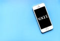 Front view of Apple iPhone with text of Vogue on the screen. Phone on pink background. Beauty flat lay. Royalty Free Stock Photo