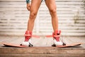 Front view on athletic female legs fixed in boots of wakeboarding board