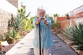 Front view of attractive smiling senior man in outdoors looking at camera holding a walking cane Royalty Free Stock Photo