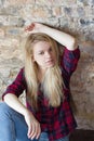 Front view of attractive white girl sitting on wooden floor Royalty Free Stock Photo