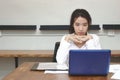 Front view of attractive young Asian business woman using laptop computer on the desk in office. Royalty Free Stock Photo