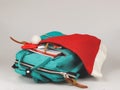 Backpack with school supplies and Christmas Santa hat on white background with copy space. Christmas party at school concept