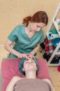 Front view beautician massaging woman's face. Salon skin care. Cosmetic procedures