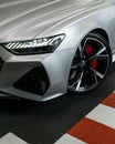 Front view of the beautiful Audi RS6 in matte silver with headlight on at the parking lot