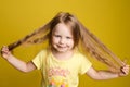 Longhaired girl in cute shirt playing with hair and twirling