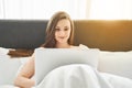 Joyous girl sitting with a laptop in bed Royalty Free Stock Photo