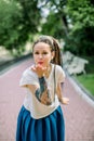 Front view of beautiful young hipster woman with dreadlocks hair style and tattoo, strolling in summer park, posing to Royalty Free Stock Photo