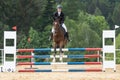 Front view of beautiful young horsewoman jumping