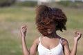 Front view of a beauty mixed race african american woman with hair blowed in air smiling at camera dancing in movement Royalty Free Stock Photo