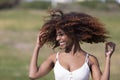 Front view of a beauty mixed race african american woman with hair blowed in air smiling at camera dancing in movement